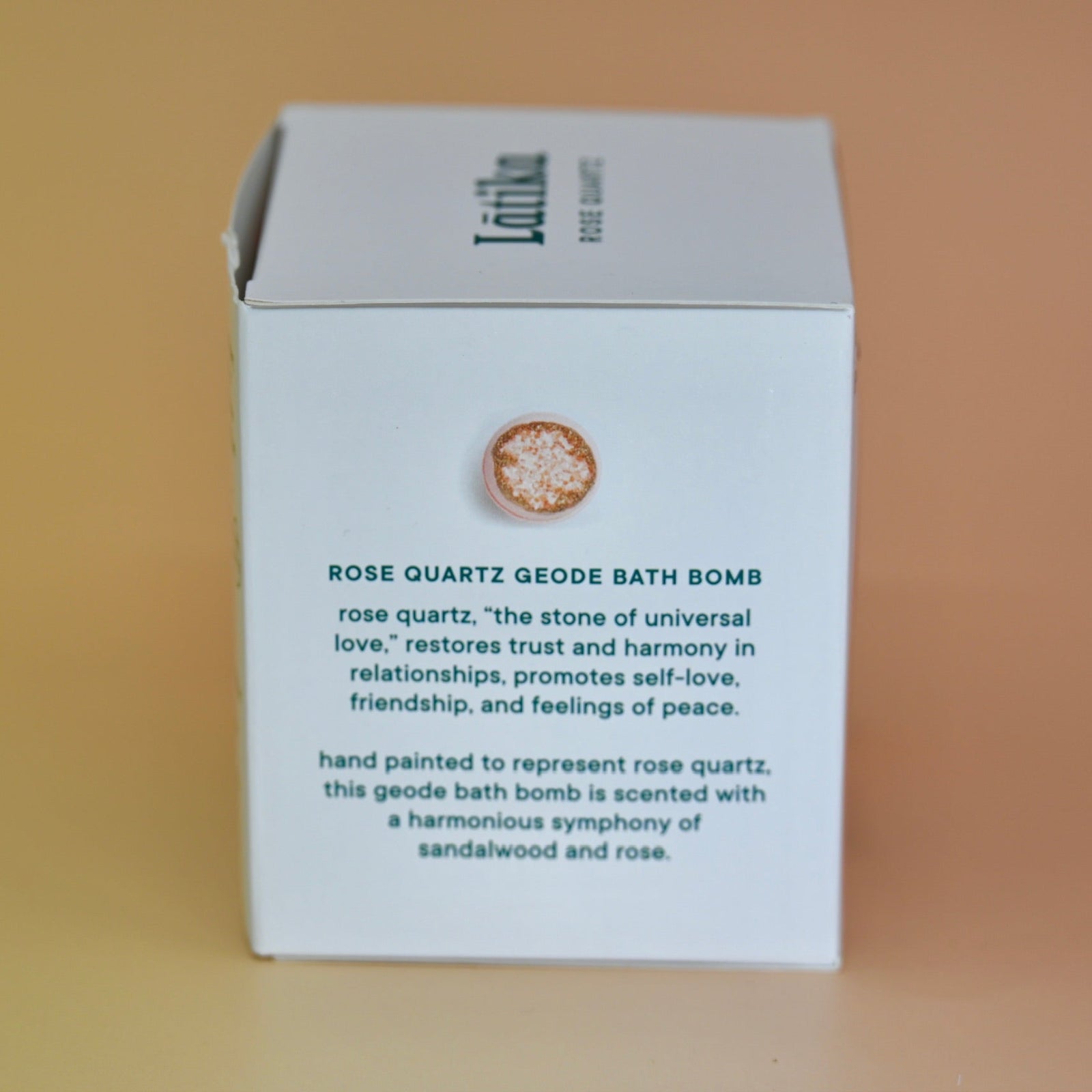 The side of the Rose Quartz Crystal Bath Bomb box on a pink background.
