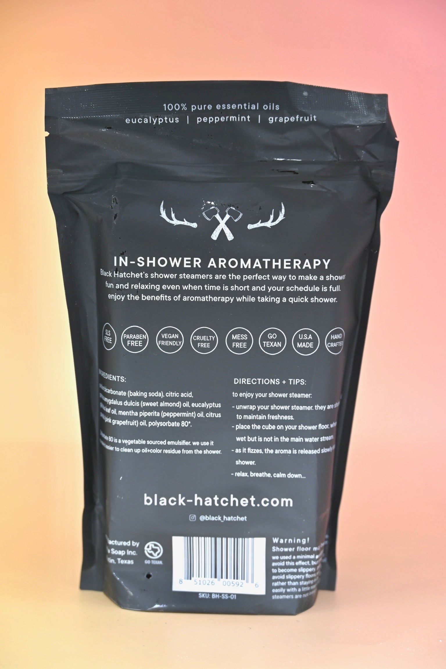 The back of the Black Hatchet Shower Steamers - Grapefruit & Mint Shower Steamers on a pink background.