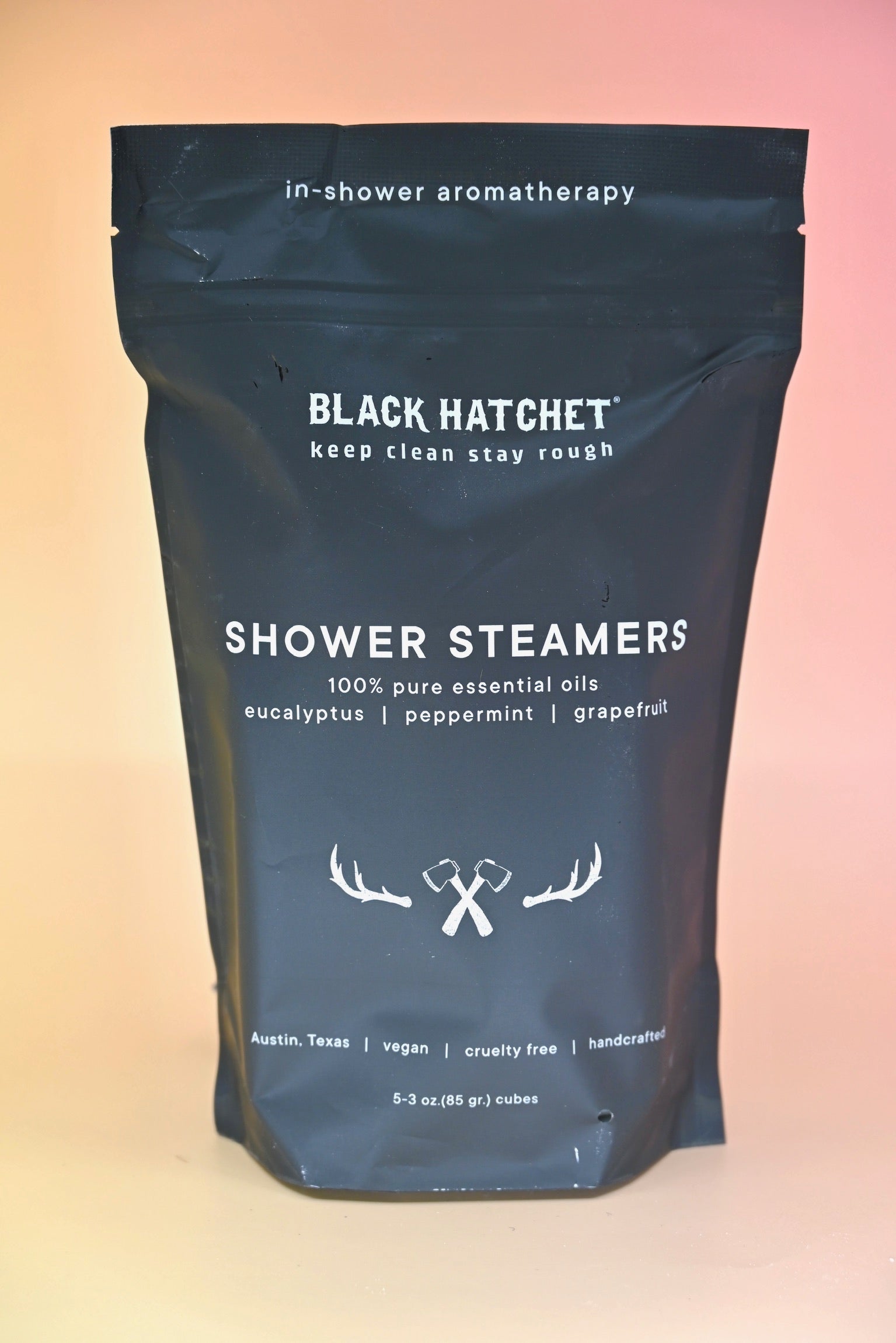 The Black Hatchet Shower Steamers - Grapefruit & Mint Shower Steamers on a pink background.
