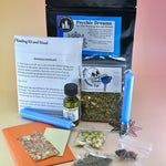 The Psychic Dreams Tea Leaf Reading and Ritual Kit on a pink and yellow background with all its contents.
