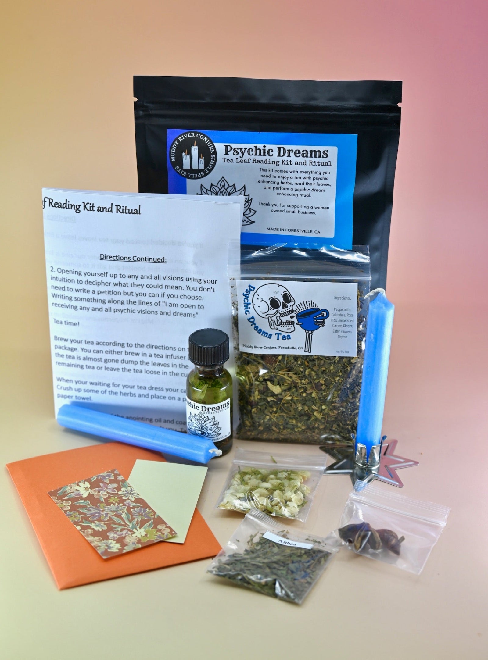 The Psychic Dreams Tea Leaf Reading and Ritual Kit on a pink and yellow background with all its contents.