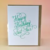 The Happy Birthday Fart Face Greeting Card on a peach-colored background.