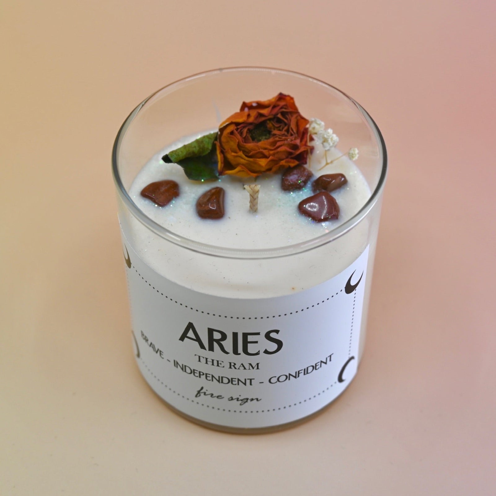 The Taurus Zodiac Crystal Candle on a peach colored background.