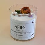 The Aries Zodiac Crystal Candle on a peach colored background.
