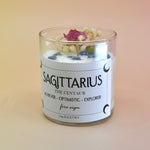 The Sagittarius Zodiac Crystal Candle on a peach colored background.