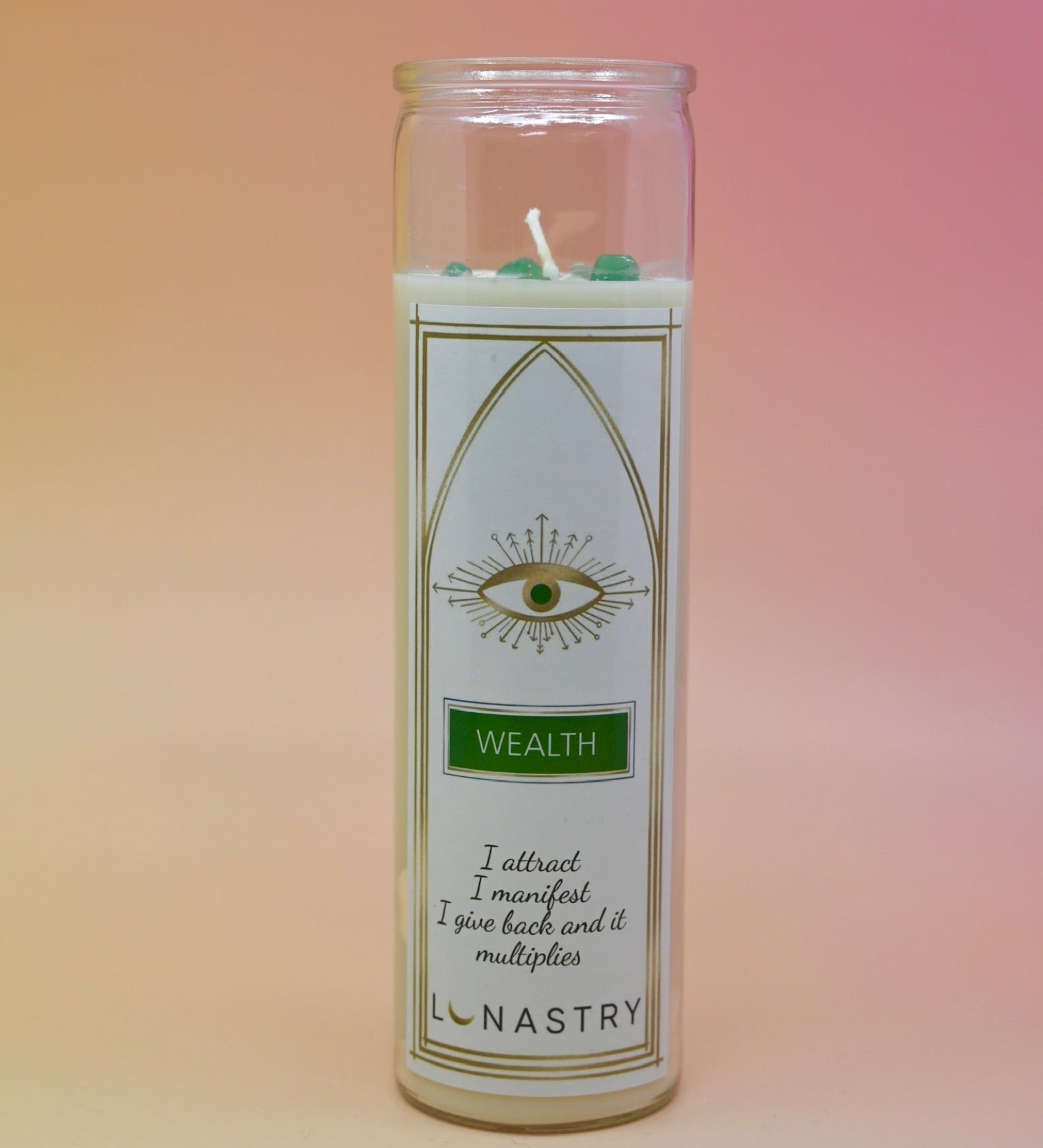 The Wealth Soy-Wax Prayer Candle on a pink and yellow background.