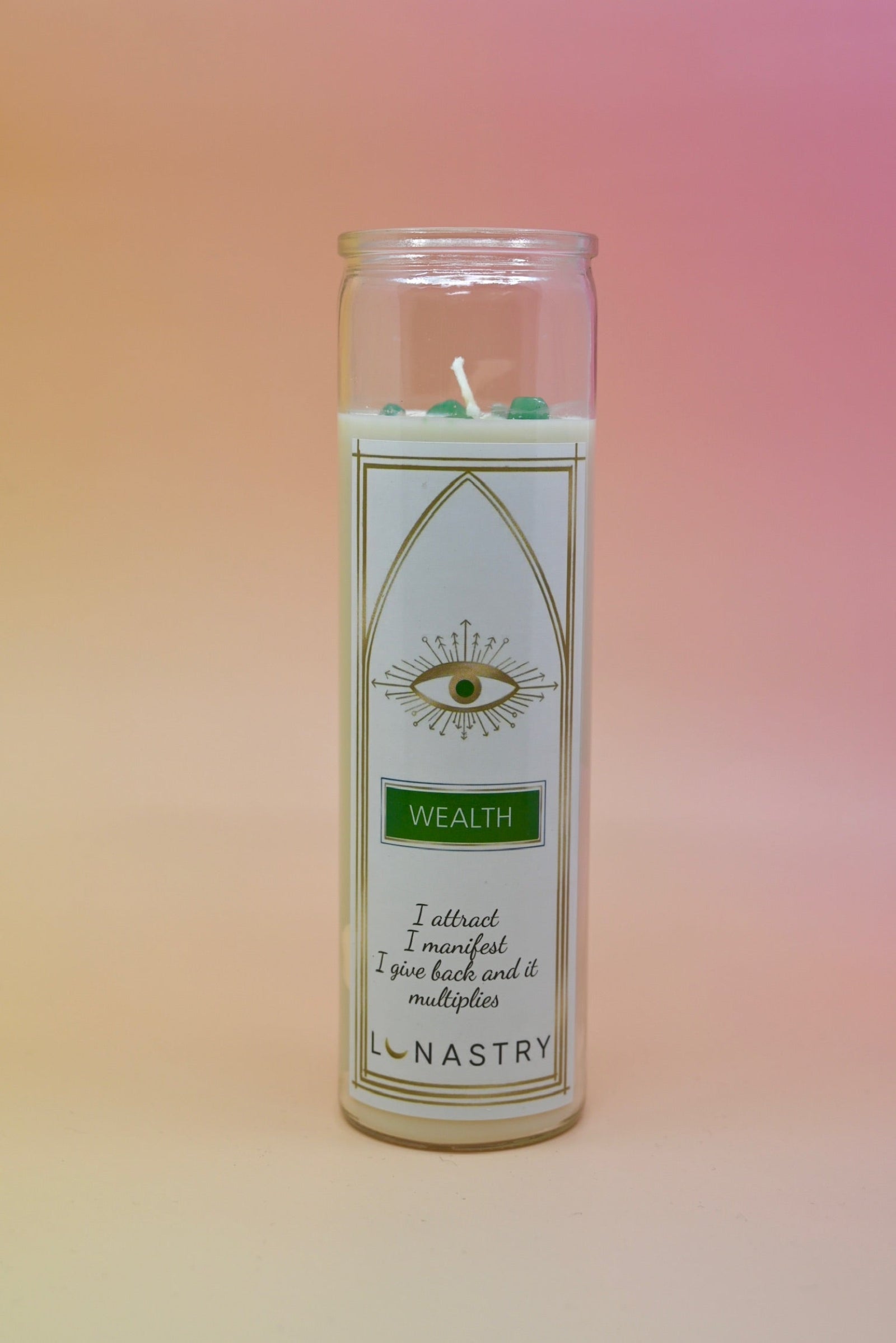 The Wealth Soy-Wax Prayer Candle on a pink and yellow background.
