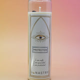 The Protection Prayer Crystal Candle on a pink and yellow background.