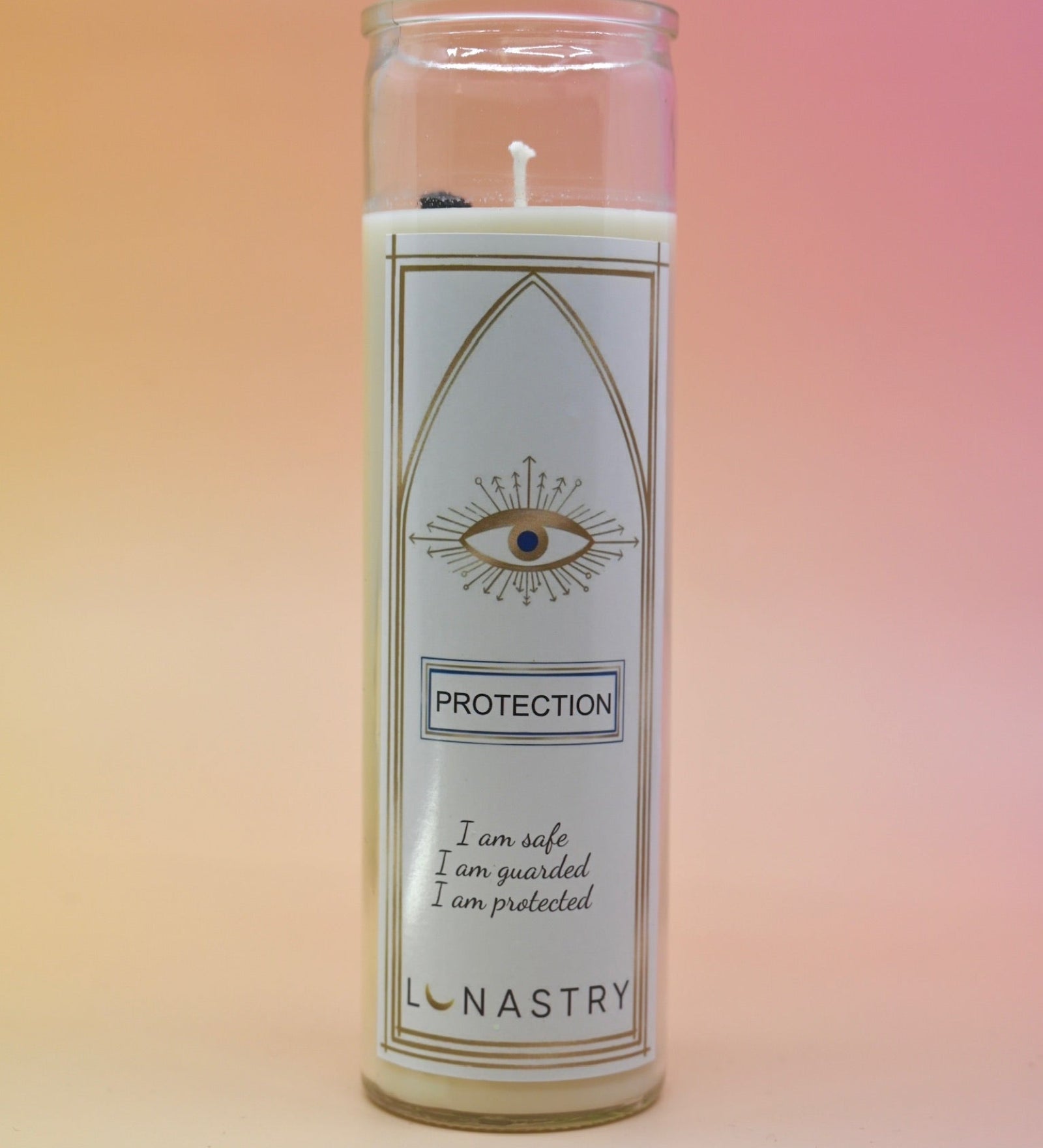 The Protection Prayer Crystal Candle on a pink and yellow background.