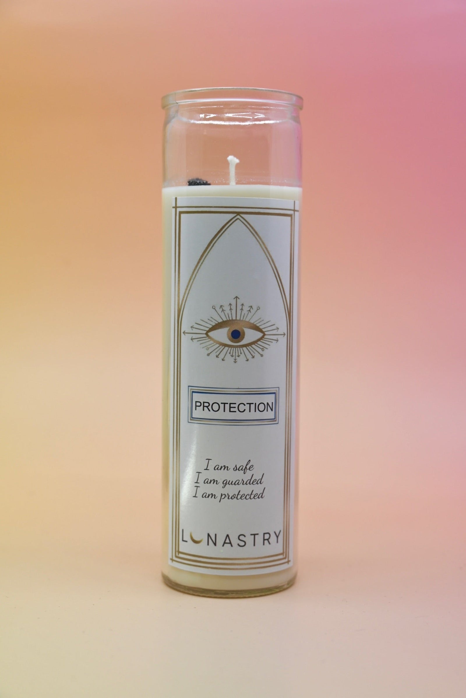 The Protection Prayer Crystal Candle on a pink and yellow background.