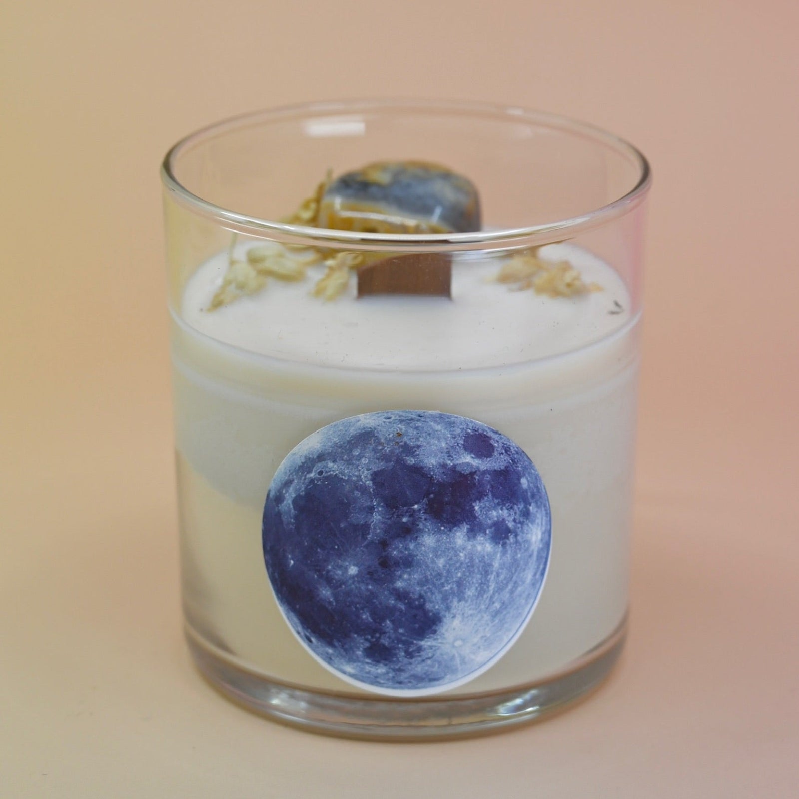 The Moonchild Crystal Candle on a pink background.
