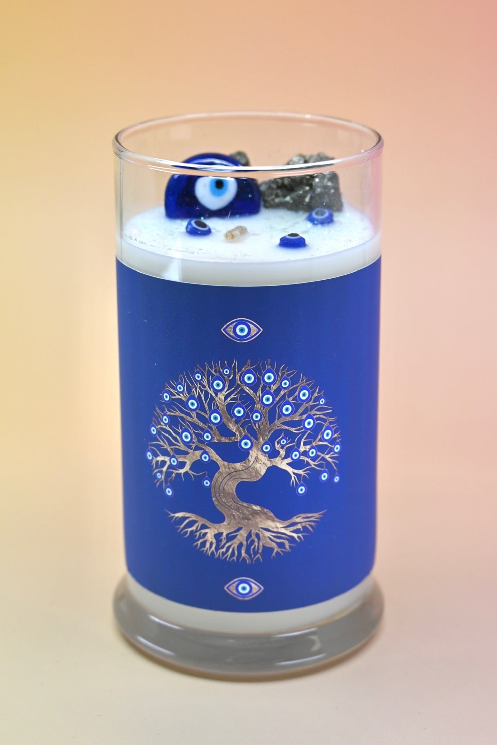 The Affirmation Evil Eye Candle - 21oz Candle on a pink background.