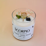 The Scorpio Zodiac Crystal Candle on a peach colored background.