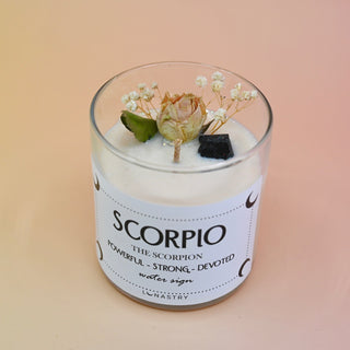 The Scorpio Zodiac Crystal Candle on a peach colored background.
