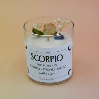 The Scorpio Zodiac Crystal Candle on a peach colored background.