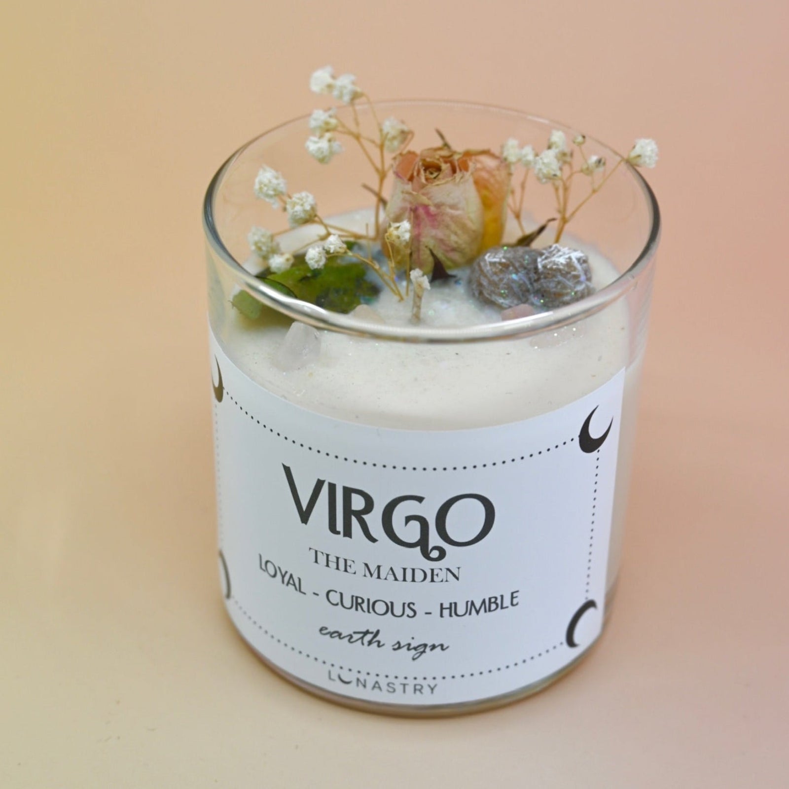 The Virgo Zodiac Crystal Candle on a peach colored background.