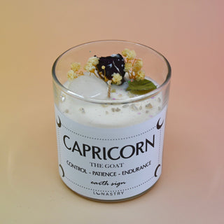 The Capricorn Zodiac Crystal Candle on a peach colored background.
