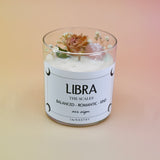 The Libra Zodiac Crystal Candle on a peach colored background.