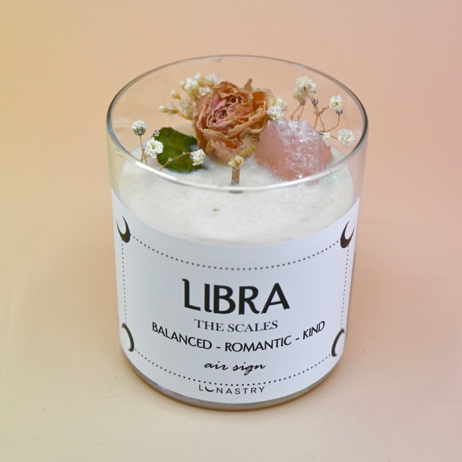 The Libra Zodiac Crystal Candle on a peach colored background.