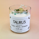 The Taurus Zodiac Crystal Candle on a peach colored background.