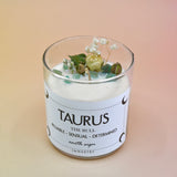 The Taurus Zodiac Crystal Candle on a peach colored background.
