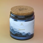 The Moons Ritual Candle on a pink and yellow background with the cork lid on.