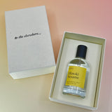 The Hinoki Sesame 50ml Unisex Eau de Parfum on a pink background in its box.