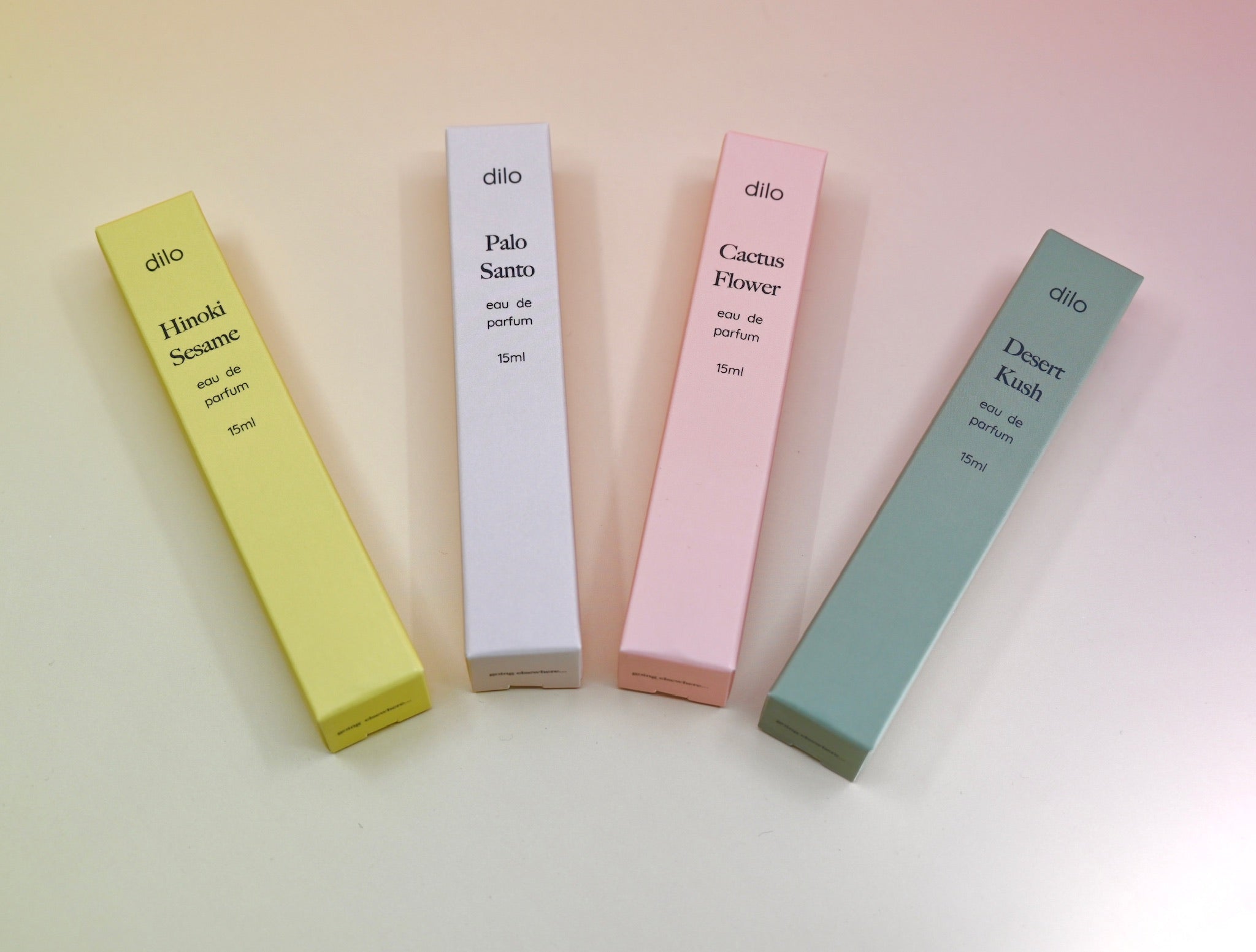 All of the travel sprayer dilo perfumes on a light pink background.