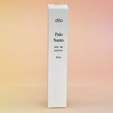 The box of the Palo Santo 15ml Unisex Eau de Parfum Travel Sprayer on a light pink background.