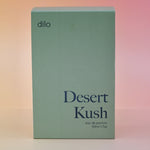 The box of the Dilo Desert Kush 50ml Unisex Eau de Parfum on a pink background.