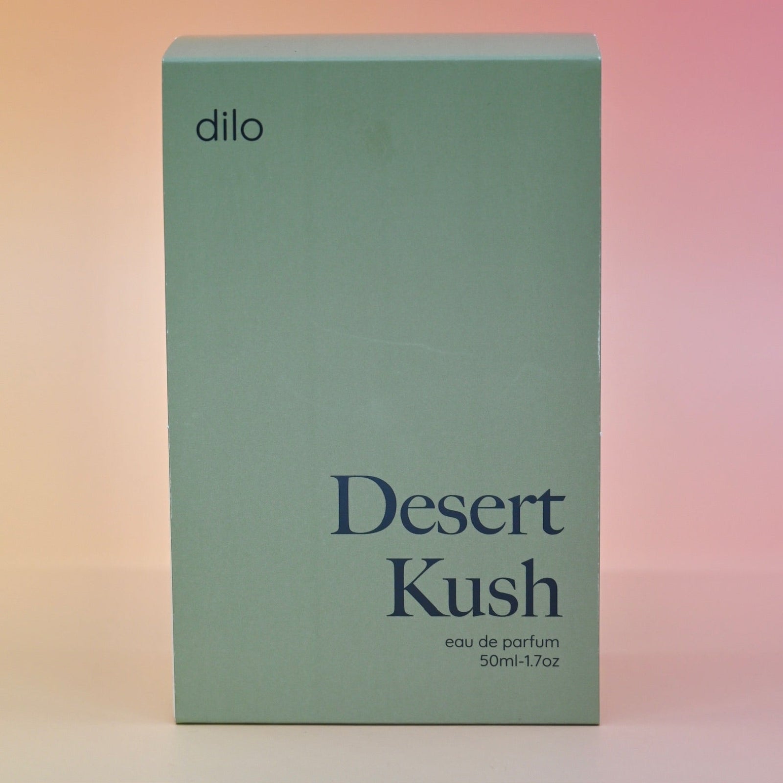 The box of the Dilo Desert Kush 50ml Unisex Eau de Parfum on a pink background.