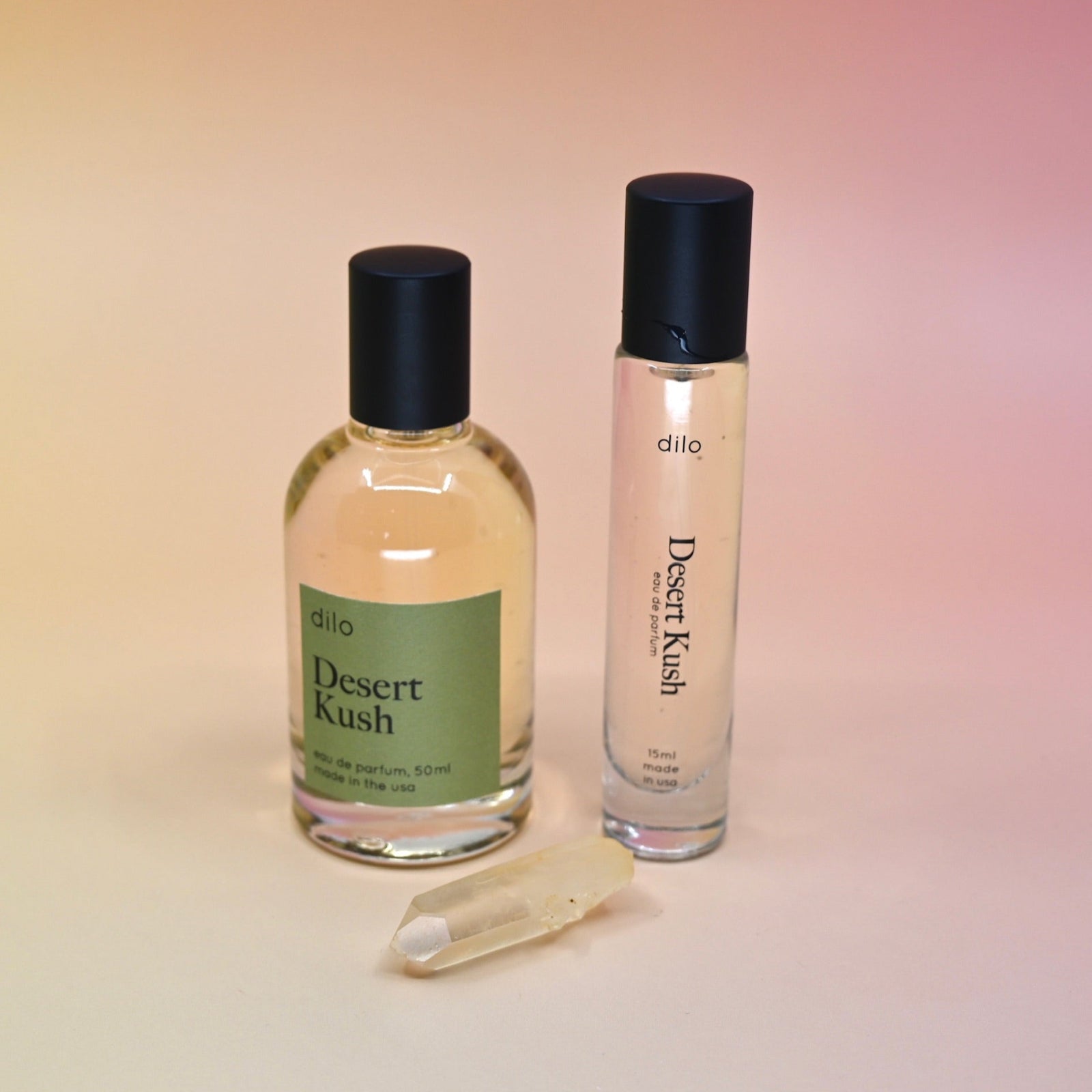 The Desert Kush 15ml Unisex Eau de Parfum Travel Sprayer and regular sized bottle on a light pink background.