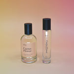 The bottle of the Cactus Flower 15ml Unisex Eau de Parfum Travel Sprayer and regular sized bottle on a pink background.