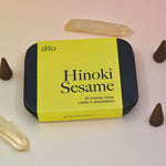 The Hinoki Sesame Cone Incense on a light pink background surrounded by incense cones and crystals.