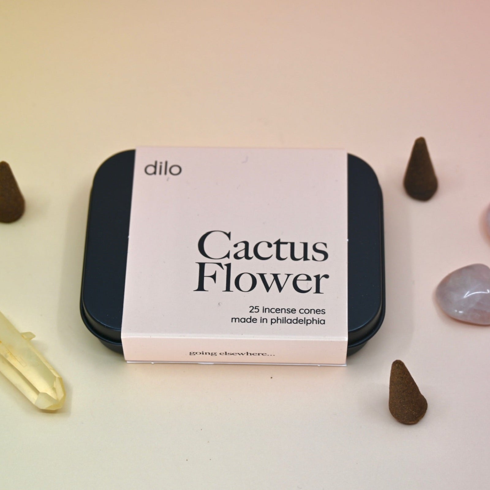 The Cactus Flower Incense Cones - Pack of 25 tin on a light pink background surrounded by crystals and incense cones.