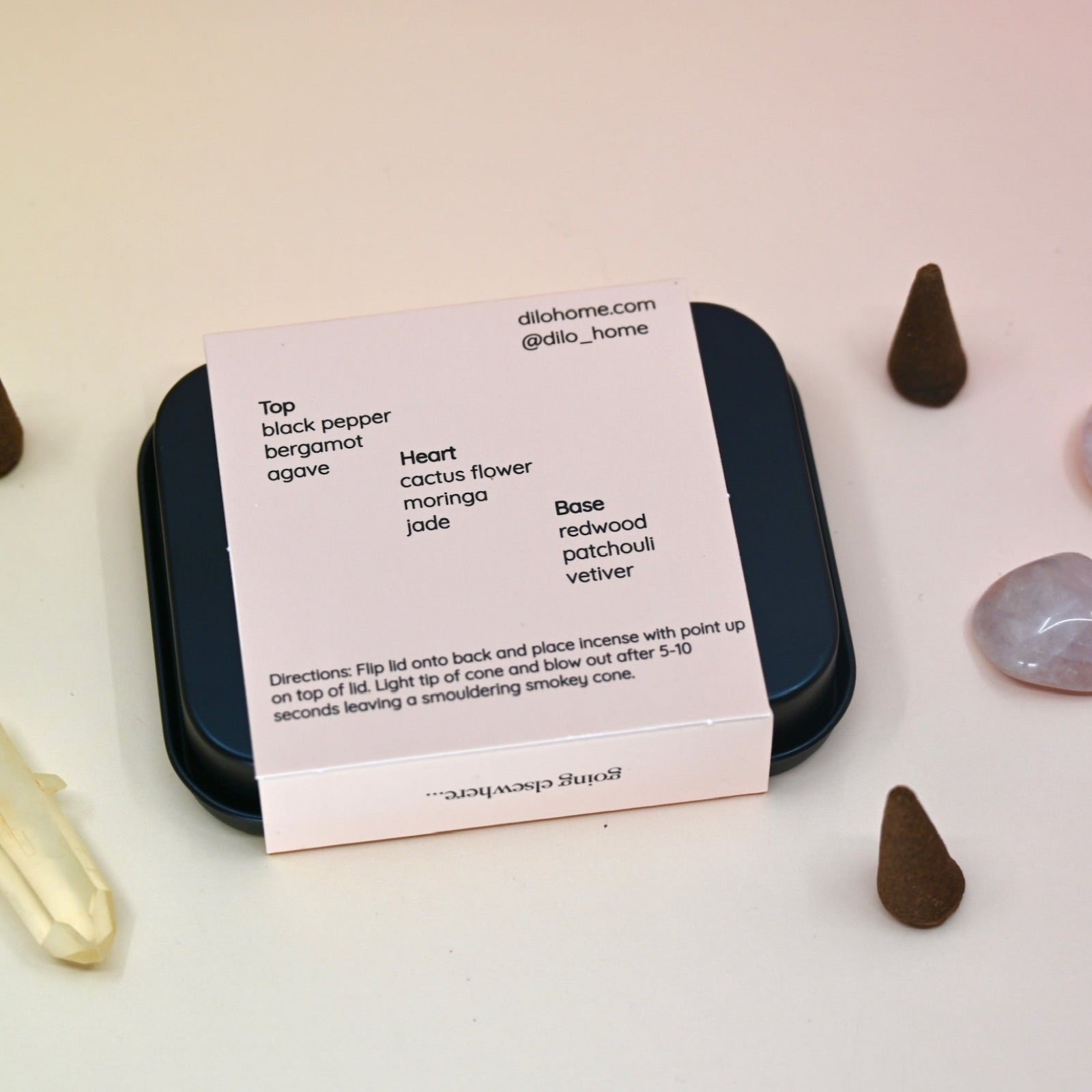 The  back of the Cactus Flower Incense Cones - Pack of 25 tin on a light pink background surrounded by crystals and incense cones.