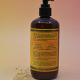 The back of the Essential Oil Cleansing Hand & Body Wash with a crystal in front of it on a light pink background.