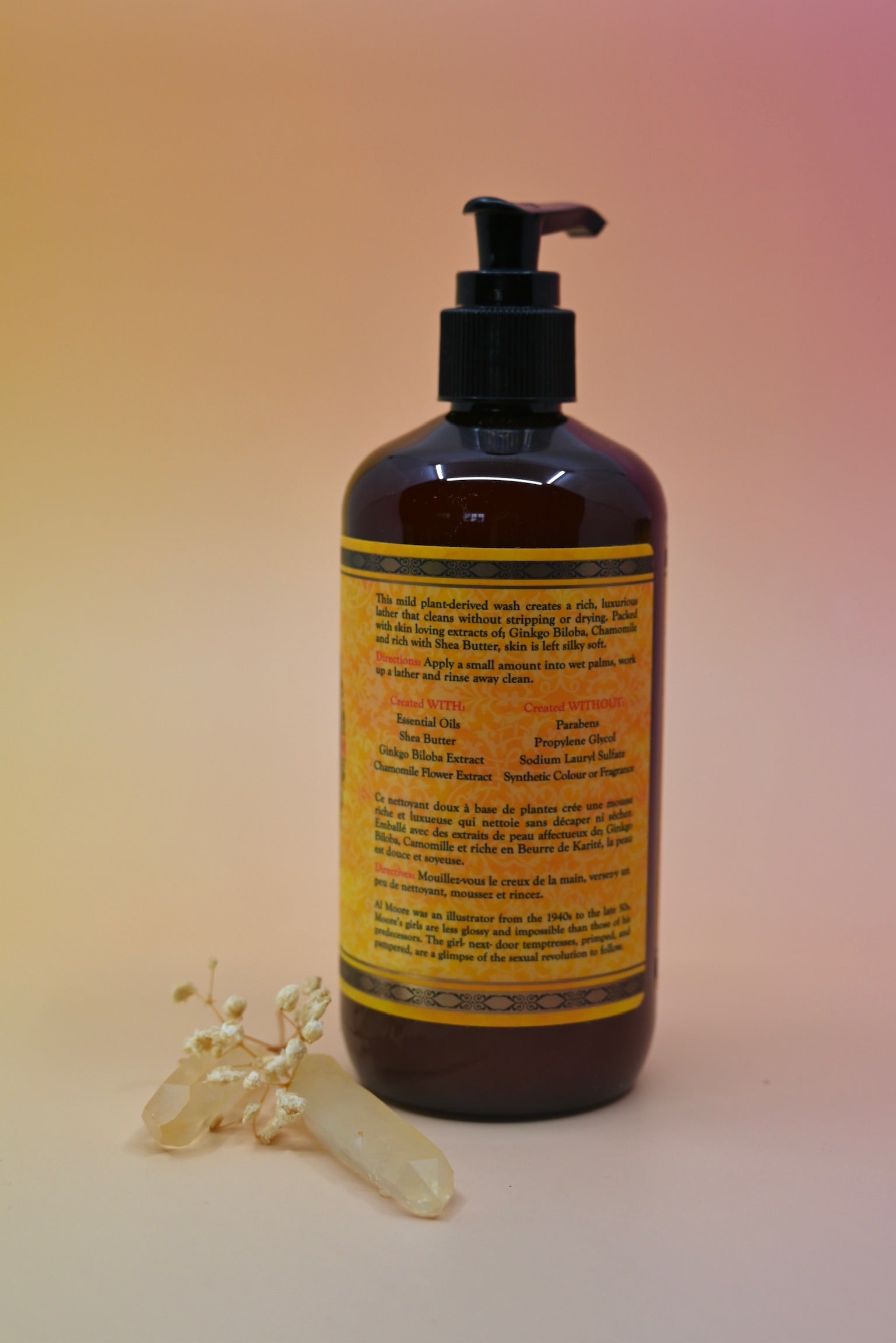 The back of the Essential Oil Cleansing Hand & Body Wash with a crystal in front of it on a light pink background.