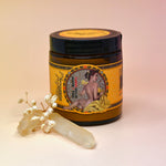 The Essential Oil Instant Hand Repair Balm with a crystal in front of it on a light pink background.