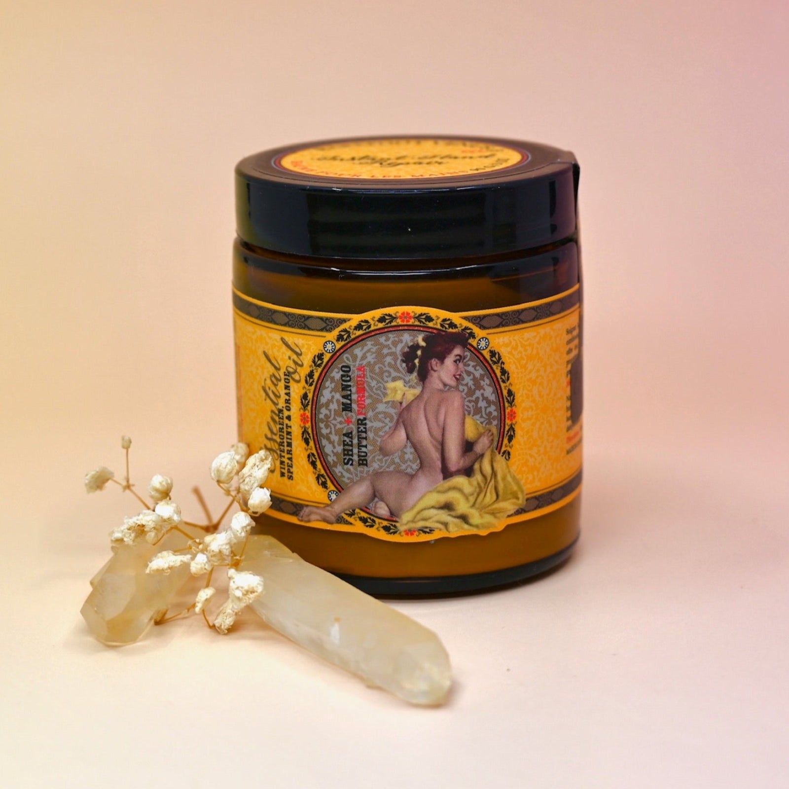 The Essential Oil Instant Hand Repair Balm with a crystal in front of it on a light pink background.