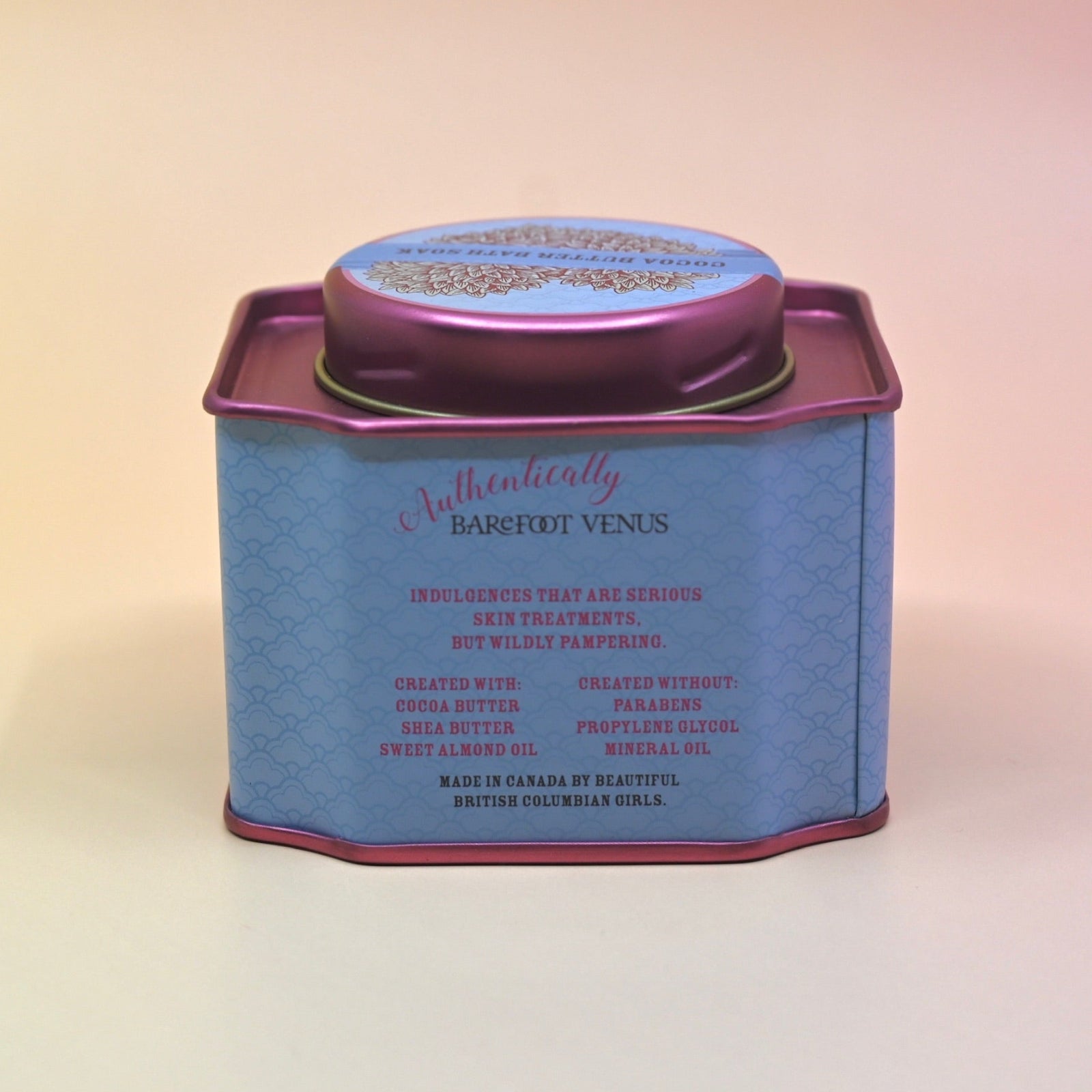 The back of the Coconut Kiss Bath Soak surrounded by crystals and dried flowers on a light pink background.