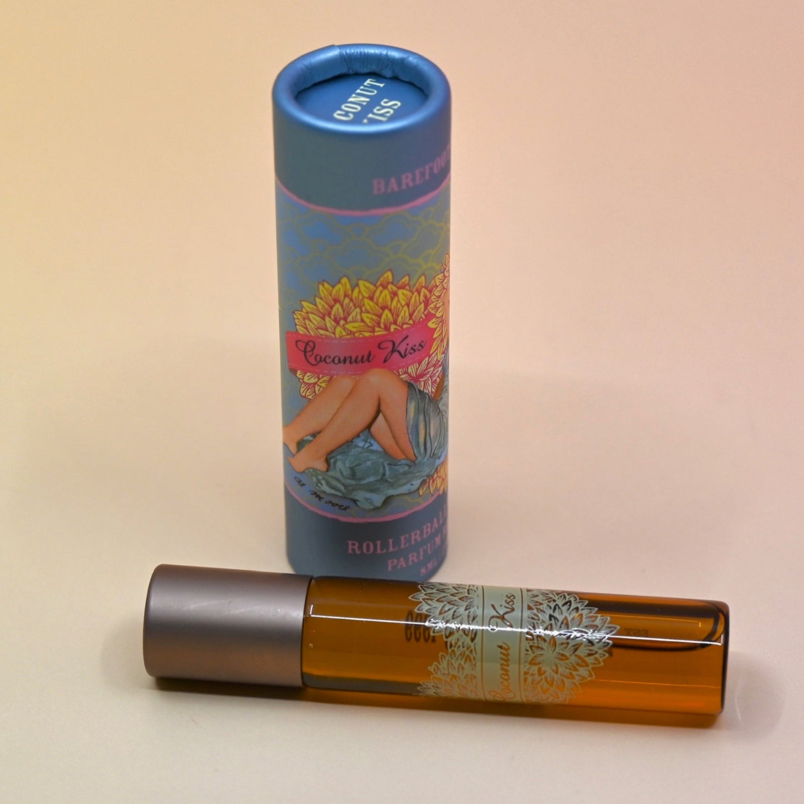 The Coconut Kiss Roll on Perfume on a light pink background.