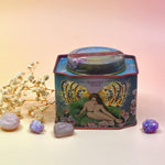 The Vanilla Effect Bath Soak surrounded by crystals and a dried flower on a light pink background.