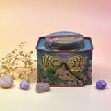 The Vanilla Effect Bath Soak surrounded by crystals and a dried flower on a light pink background.