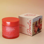 Red jar of magnesium balm with a matching box on a beige background