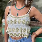 Model wearing embroidered cotton-linen crop tank top with green floral detail and scalloped hem