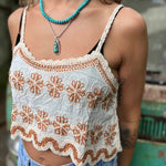 Open crochet lace front of boho crop tank top in ivory – model showing breathable fabric design close up view of the tank top and the orange flowers