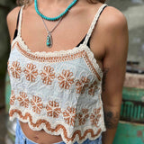 Open crochet lace front of boho crop tank top in ivory – model showing breathable fabric design close up view of the tank top and the orange flowers