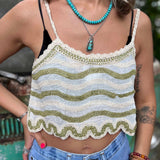 Model wearing embroidered cotton-linen crop tank top with green floral detail and scalloped hem close up view