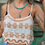 Model wearing embroidered cotton-linen crop tank top with orange floral detail and scalloped hem close up view